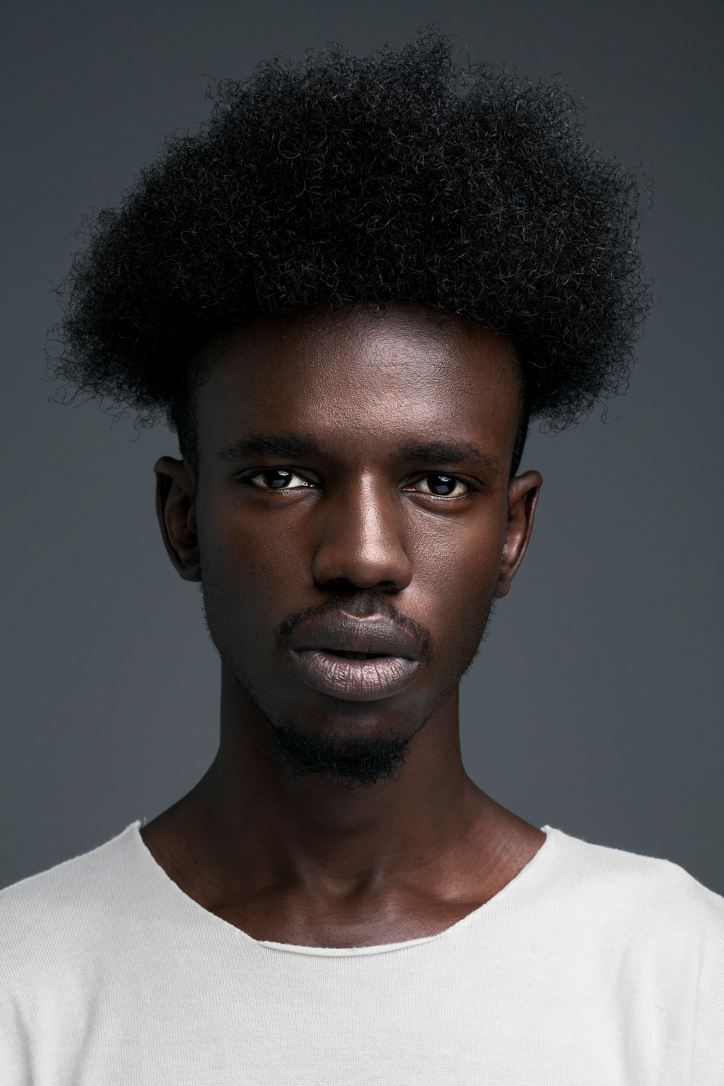 Portrait of artist for a print campaign imagined for tattoo MTL. Grey background, deep color skin tones.